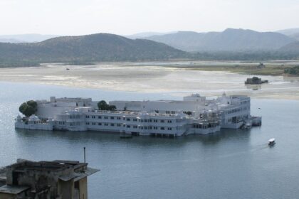 A vibrant view of Udaipur’s Lake Pichola with a traditional boat, one of the freshening places to visit in Rajasthan in June.