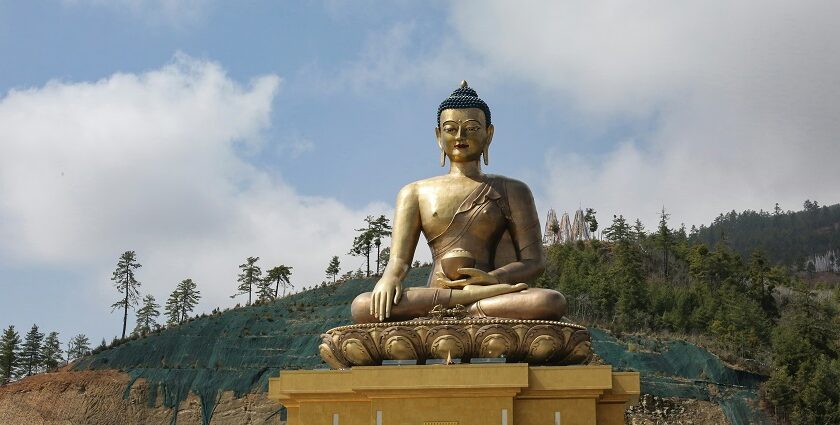 Panoramic view of Buddha in Thimphu, nestled among lush green hills and clear blue sky