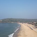 An aerial picture of a beach in Goa with an island visible in the background