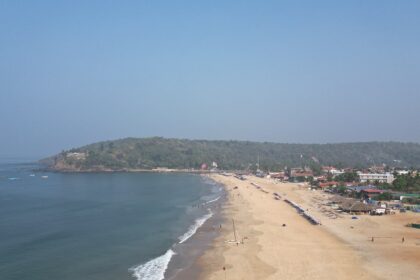 An aerial picture of a beach in Goa with an island visible in the background