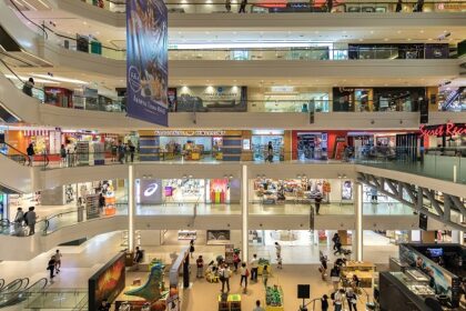 Spacious and modern shopping mall in Malaysia with glass windows and sleek architecture.