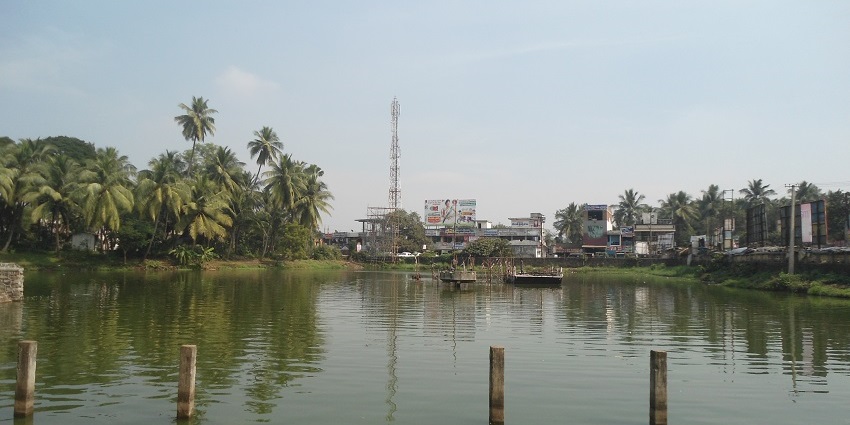 A stunning view of a pond near a temple for everyone to explore during the daytime.