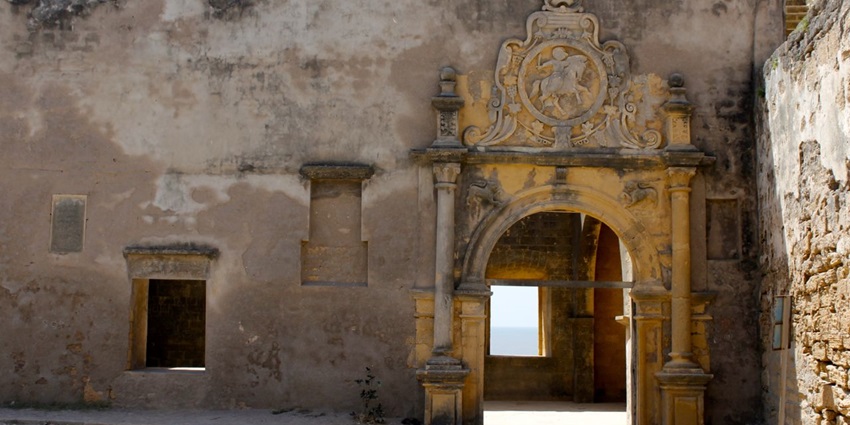 An interior view of a historic fort, featuring intricate stone arches and columns.