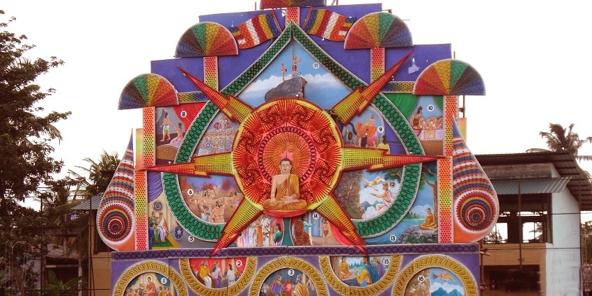 An enchanting view of a poson pandal with colourful decorations during the daytime.