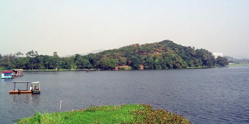 Powai Lake with lush greenery, ideal for birdwatching and boating.