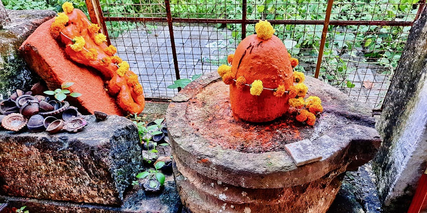 An ancient Shiva temple in Delhi with people worshipping the Shiva Linga and putting garlands