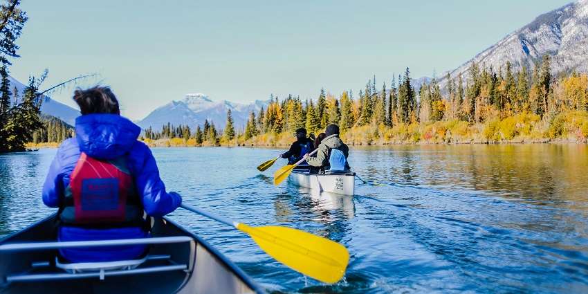 A stunning view of three people riding a kayak on sparkling clear waters during the day.