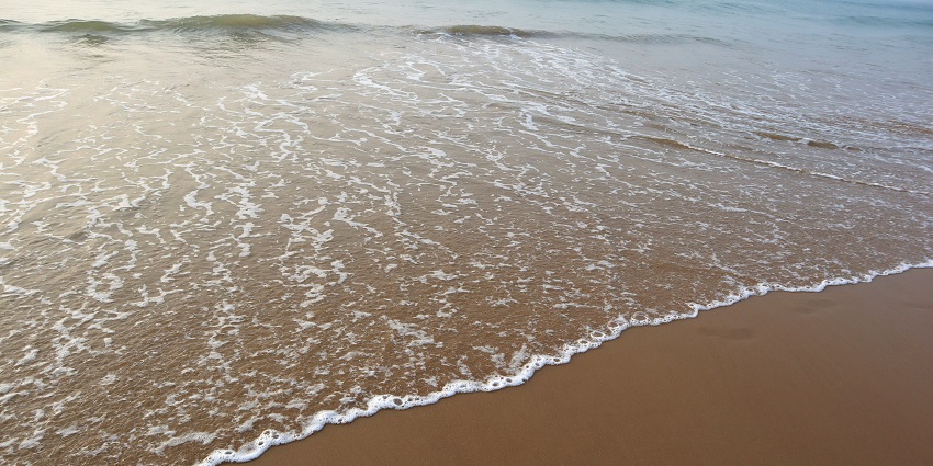 Sunset over Puri Sea Beach with soft rays glistening on waves near Sudam Sand Art Museum