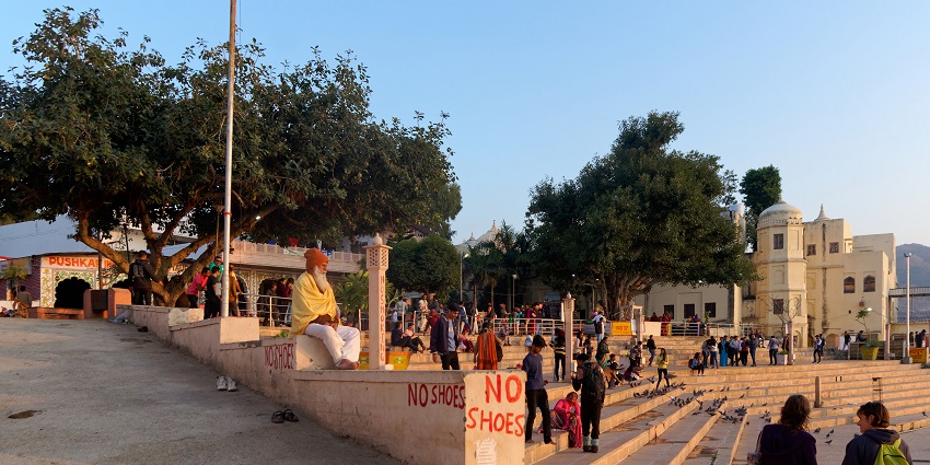 View of the ghats at Pushkar Lake, with steps leading to the water and temples in the background