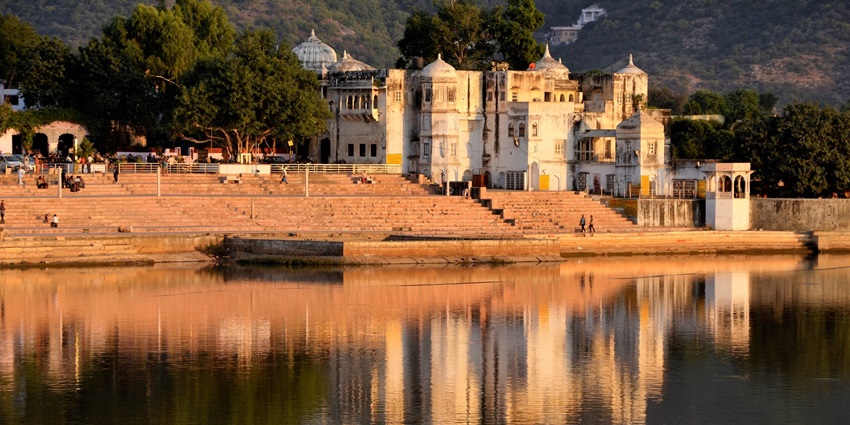Serene view of Pushkar Lake in India, surrounded by white-washed ghats and temples