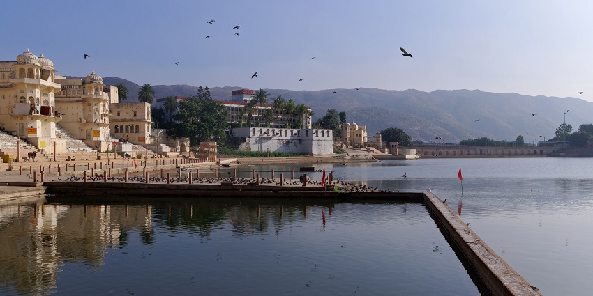 The serene waters of Pushkar Lake, a major tourist attraction near Brahma Temple, surrounded by ghats and temples.