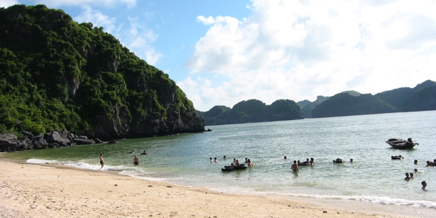 A picture of visitors enjoying at a beautiful beach with golden sand and turquoise waters