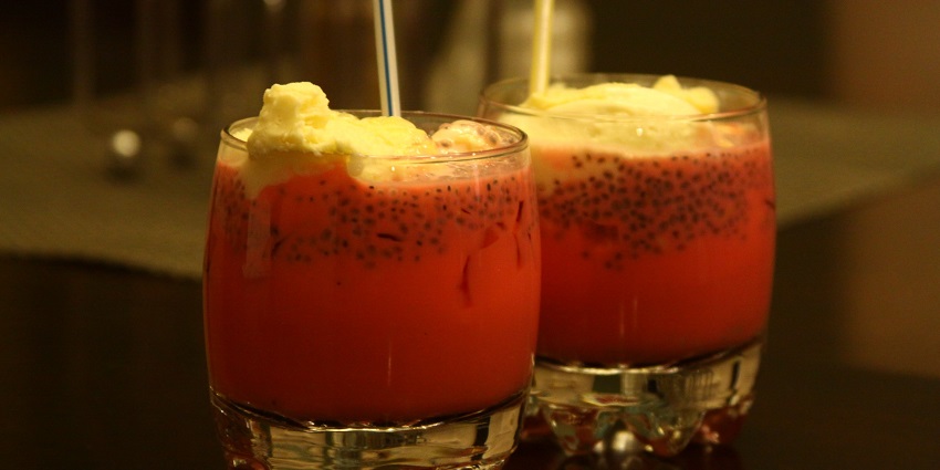Image of falooda kulfi served on two glass with colourful ice cream and fruit mixed