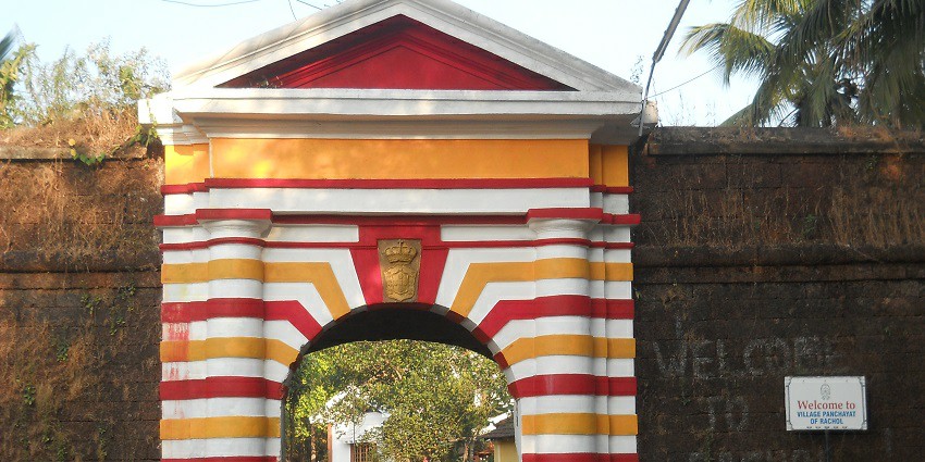 Image of Arch of Rachol Fort in Goa with lush greenery surrounding during day time
