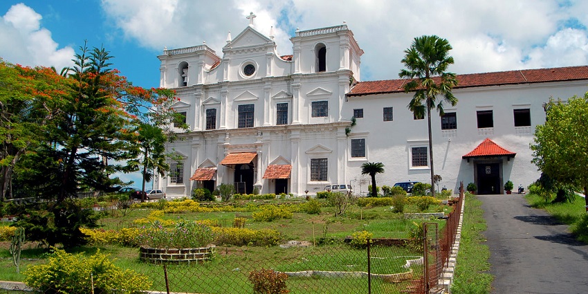 A picture of a historical building in Goa with a garden in front of it. One of the best places to visit near Margao.