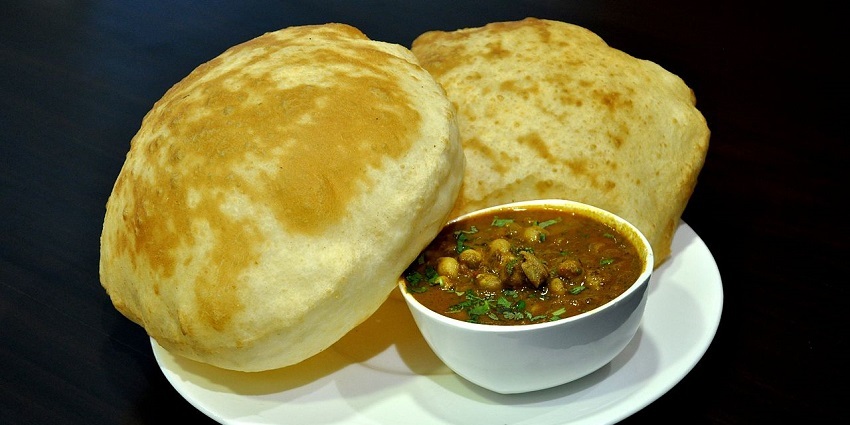 Chole bhature served with spicy chickpea curry and fluffy, golden bhatura bread - street food in Khan Market