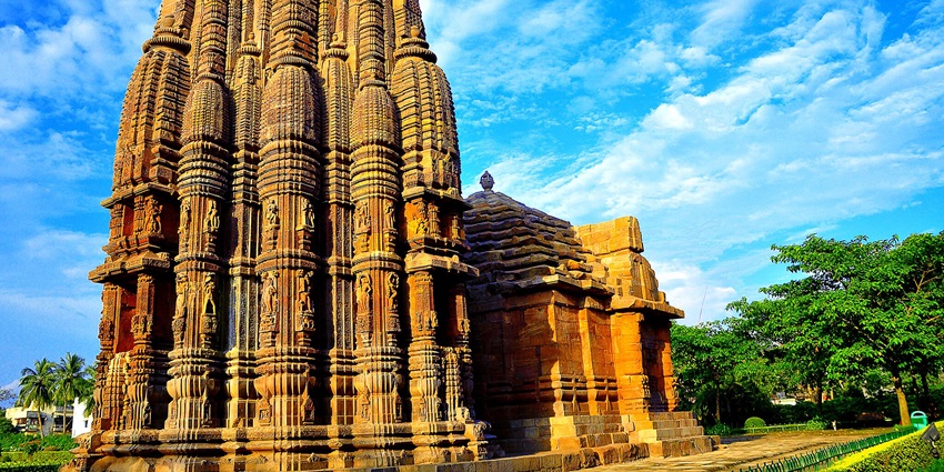 A tall stone structure with numerous pillars, showcasing the beauty of the Rajarani Temple.