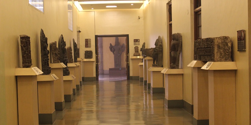 A beautifully lit exhibit in a popular museum in Ajmer displaying an intricate artefexts and showcased on a gallery wall.