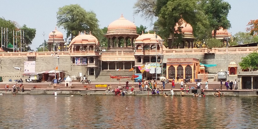 View of Ram Ghat in Ujjain, showcasing the riverfront with steps, temples, and pilgrims.