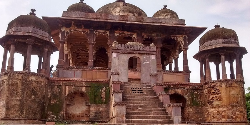 An image of Ranthambore Fort, a historic stone fort perched on a hill amid dense forest.