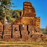 A breathtaking view of an old fort in Chhatisgarh surrounded by lush greenery in the day.