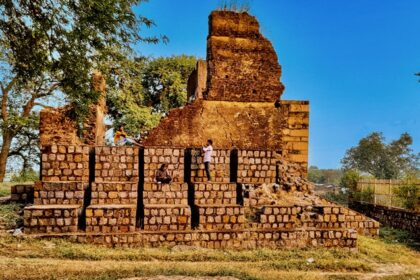 A breathtaking view of an old fort in Chhatisgarh surrounded by lush greenery in the day.