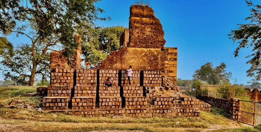 A breathtaking view of an old fort in Chhatisgarh surrounded by lush greenery in the day.