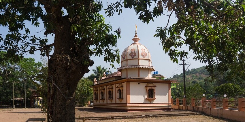A serene view of the famous Ravalnath Temple surrounded by lush green vegetation.