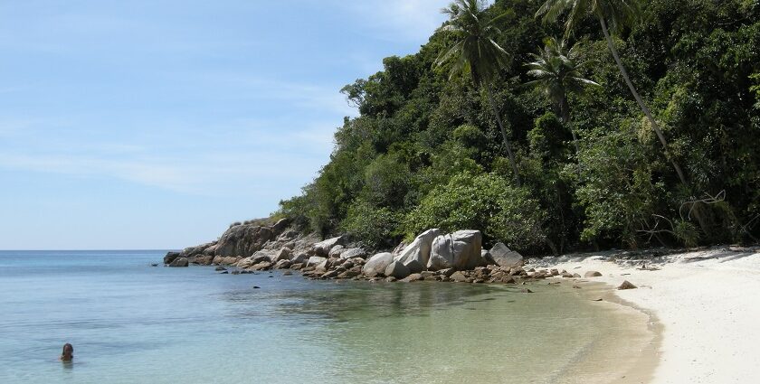 A serene view of Rawa Island, showcasing its clear blue waters and lush greenery.