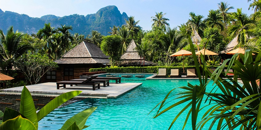 A cosy brown bench beside a sparkling swimming pool, inviting relaxation and leisure.