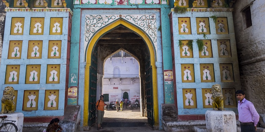 An image showing the entrance of Rewa Fort, with a background of historic architecture and with people around.