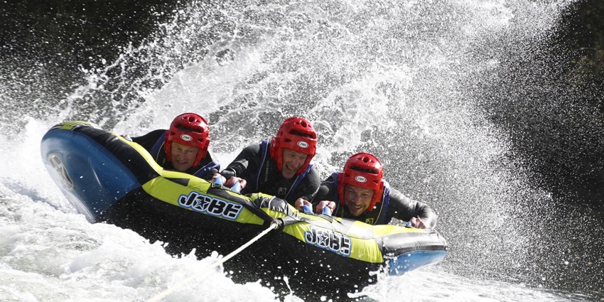 Image of three travellers on ring ride on the beach enjoying the water sports