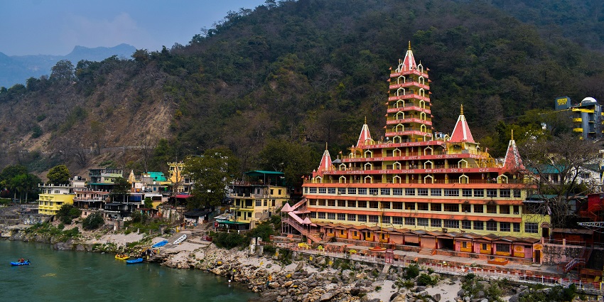 A breathtaking view of Rishikesh surrounded by temples and lush greenery during the day.