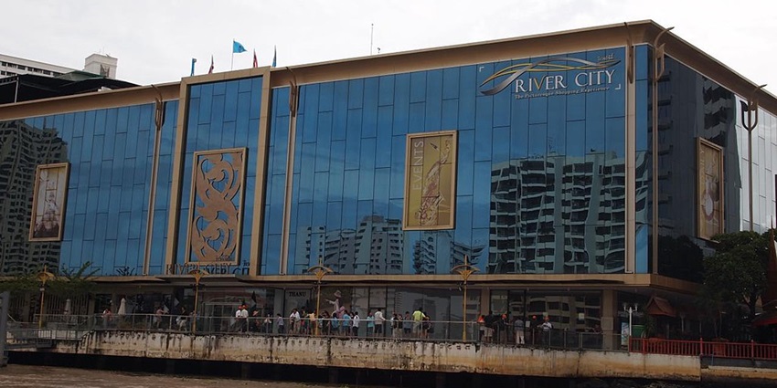 River City Mall in Bangkok with river passing by and people standing outside the mall.