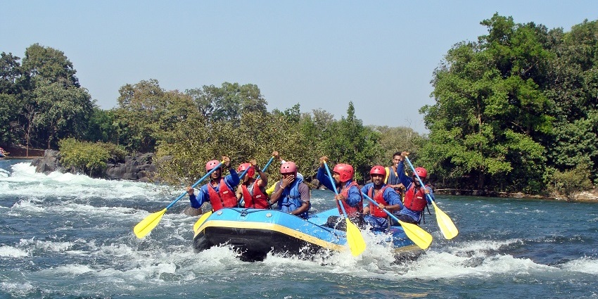 A group of six adventurers rafting through the gushing white water of the Kali River.