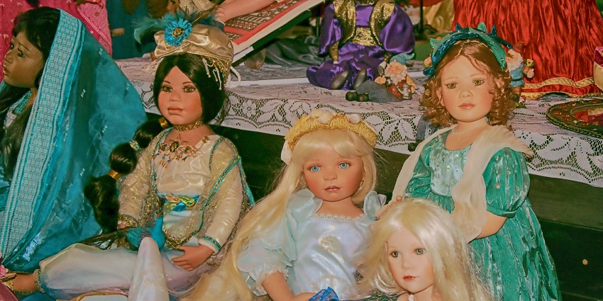 Inside Rotary Midtown Doll Museum, showcasing a diverse collection of colorful dolls on display.