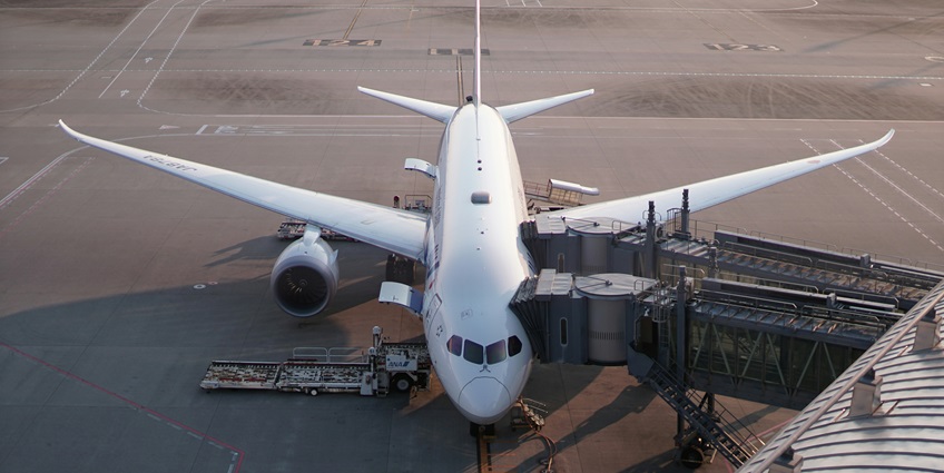 A glimpse of an aeroplane at the runway attached to a walking passage for passengers.