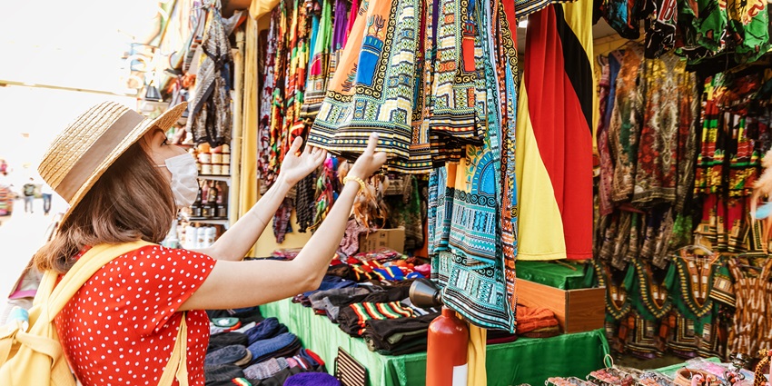 A tourist looking through vibrant local fabrics of Surat at Sahara darwaja, ideal spot for a local essence