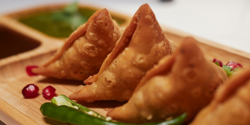 Delicious samosa chaat at Moti Mahal garnished with sev and chutney