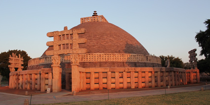 An image showing the Sanchi Stupa's magnificent dome and intricately carved gateways depict Buddhist motifs.