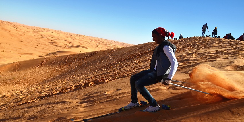 Thrilling sandboarding adventure on golden dunes, blending excitement and desert beauty