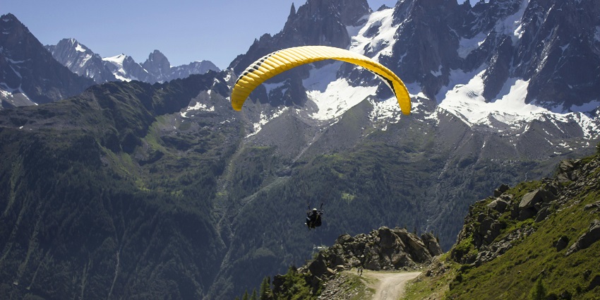 Image of a person paragliding in the beautiful mountains enjoying the snow