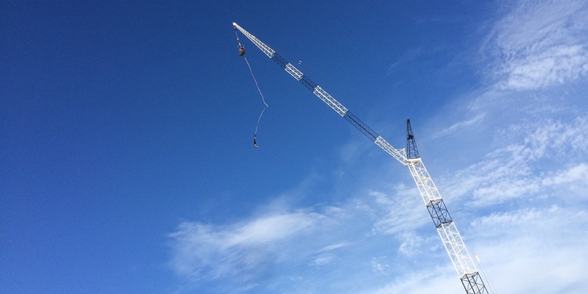 A person in mid-air during a bungee jump, showcasing the thrilling action of the jump.