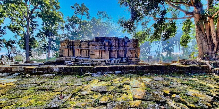 A sculpture in lush greenery inside Sarna Mandir, a temple similar to Bhoarmdeo Temple