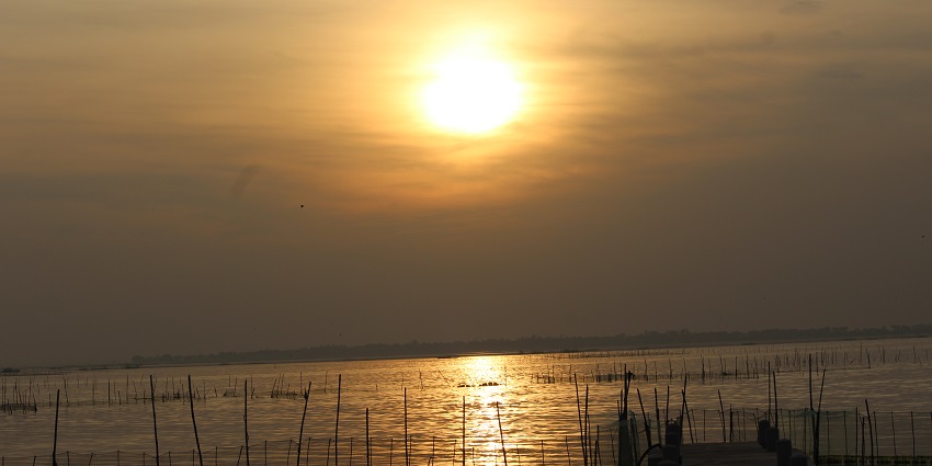 A beautiful view of sunset near a water body in Satapada, located in the state of Odisha.