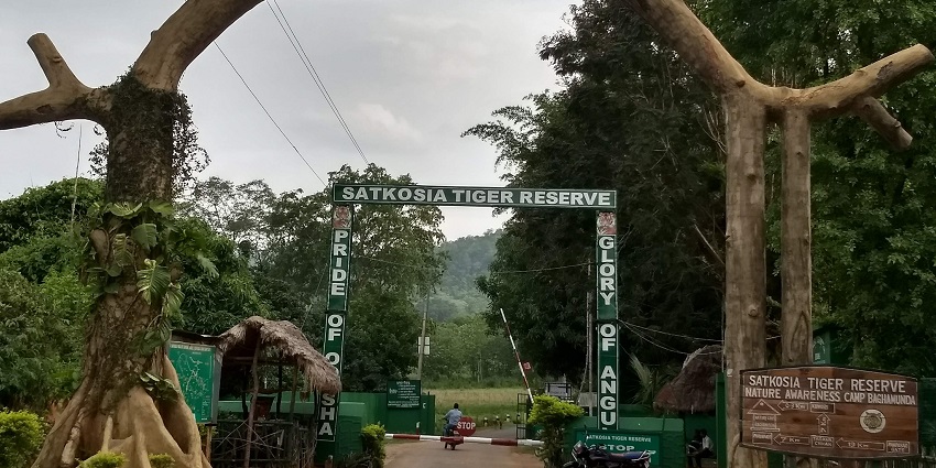 Entrance to Satkosia Tiger Reserve nature awareness camp with forested hills in the background.