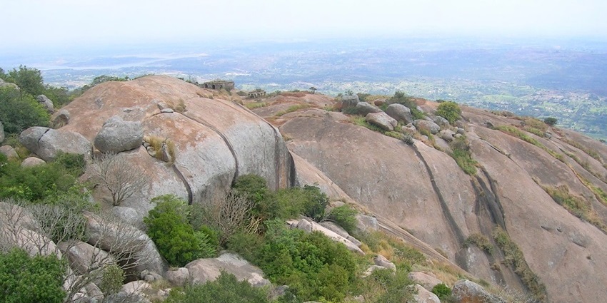 Scenic view of Savandurga hills surrounded by greenery and clear skies.