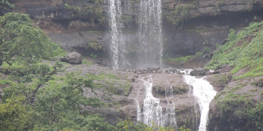 Chiplun tourist places feature Sawatsada Waterfall, the Majestic cascade amidst lush greenery and hills.