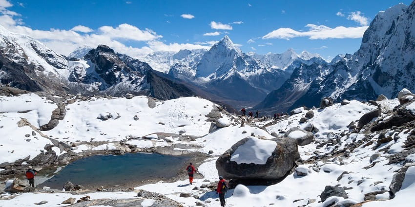 A tranquil mountain lake in Nepal's Chola Valley, encircled by majestic.