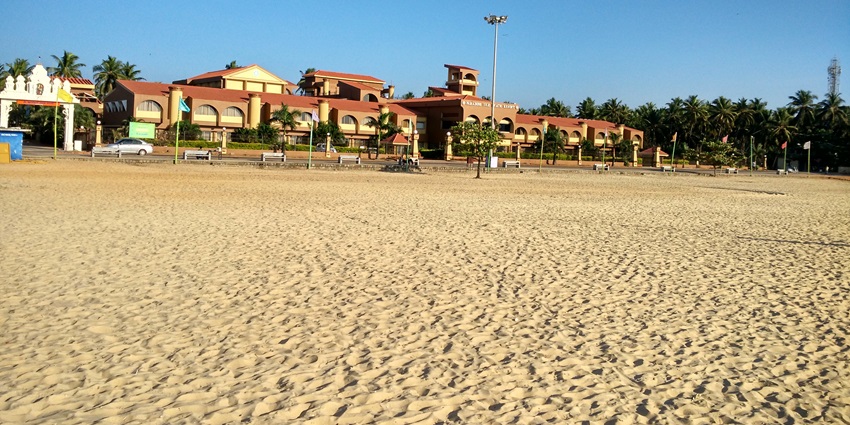 A picture of a serene beach with golden sands and a stunning resort for tourists